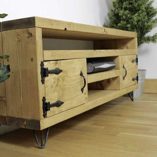 Solid wood chunky rustic tv unit in a medium oak finish, featuring 2 compartments with black metal handles for additional storage.  Handcrafted in the New Forest.